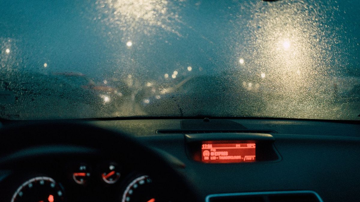 View through a rain covered windshield at night from the driver's seat